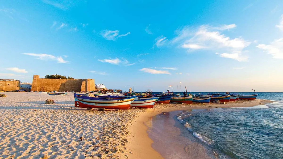 Barcas de pesca en la playa de Hammamet, Túnez, junto a la fortaleza frente al mar.